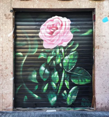 Graffiti de rosa pintada a mano en persiana de floristería en Barcelona