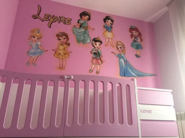 Mural infantil pintado a mano en habitación rosa con princesas Disney Blancanieves, Cenicienta, Bella, Ariel, Jasmine, Elsa y Anna, personalizado con el nombre Leyre