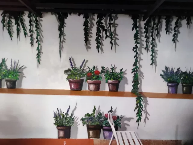 Mural trampantojo de macetas y plantas pintado a mano en patio interior
