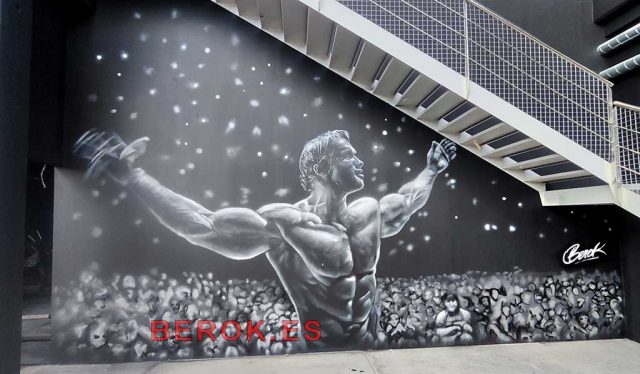 Graffiti realista Arnold culturismo clásico en gimnasio 24h-para-gimnasio-Arnold-Schwarzenegger-Mr-Olympia Graffiti culturista Arnold Schwarzenegger gimnasio mural blanco y negro con efecto luces escenario y público difuminado