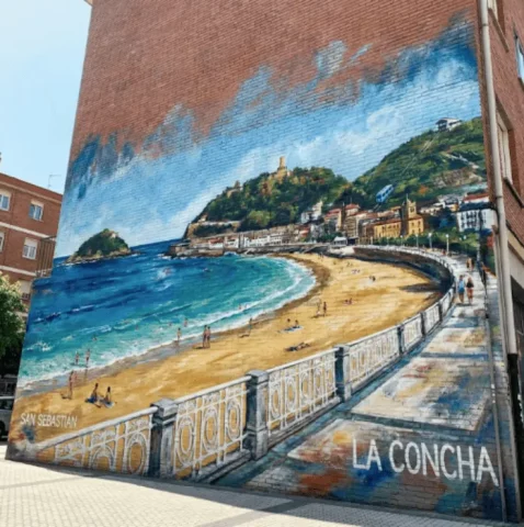 Graffiti profesional de la bahía de La Concha en fachada urbana de San Sebastián, muralismo en País Vasco.