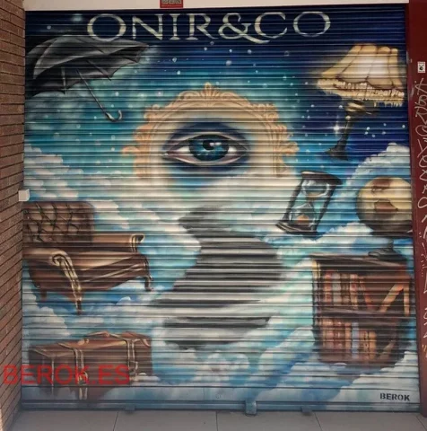 Proceso de graffiti en persiana con sprays en el suelo y mural surrealista en desarrollo