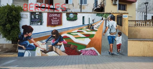 Mural realista del Corpus de Sitges con alfombras florales en Plaça Catalunya
