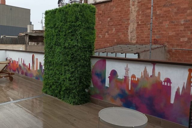Mural skyline Barcelona para terraza de hotel Terraza de hotel con mural del skyline de Barcelona en colores acuarela y jardín vertical.