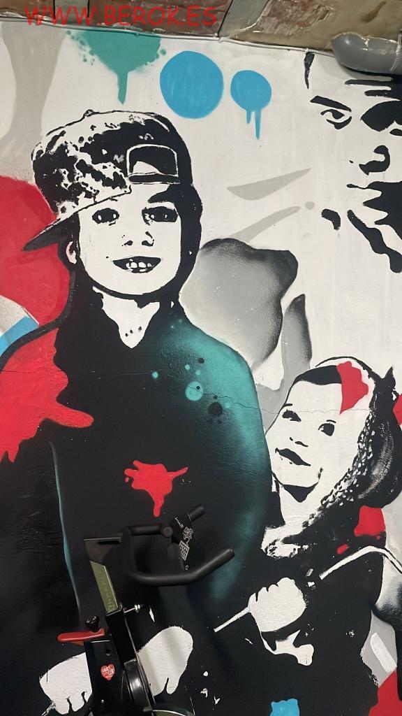 Graffiti familiar en vivienda con retratos de dos hijos y rostro inspirado en Mohamed Ali en estilo urbano.
