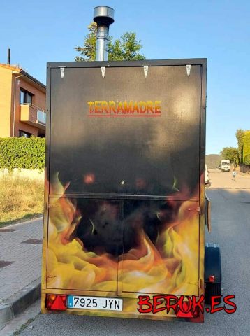 Parte trasera de remolque para pizzas decorada con graffiti de llamas y logotipo Terramadre.