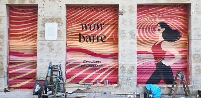 Mural graffiti para negocio Wow Barre con ilustración femenina y fondo psicodélico en persianas
