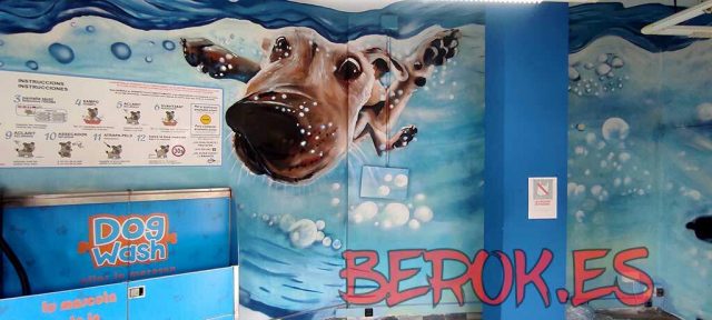 Mural para Dog Wash en Sitges con perro nadando bajo el agua y burbujas azules.