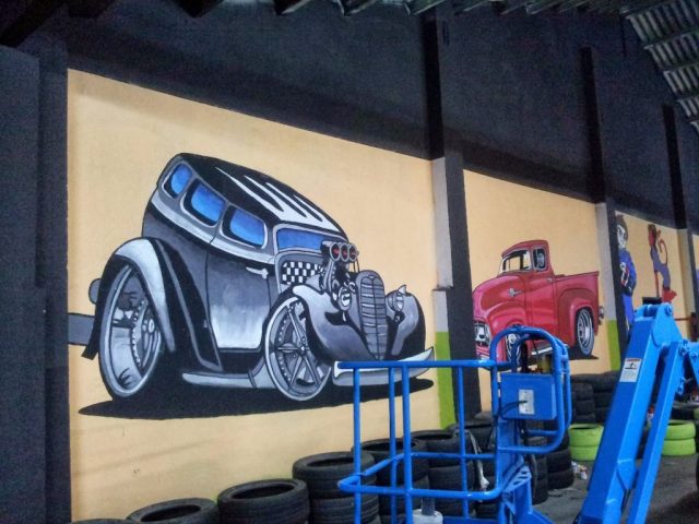 Mural coches clásicos hot rod pintados en pared de nave industrial