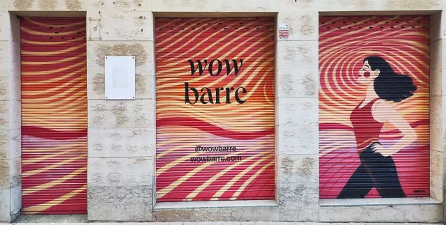 Graffiti en persianas metálicas para centro Wow Barre con diseño ondulado en tonos rosa y naranja