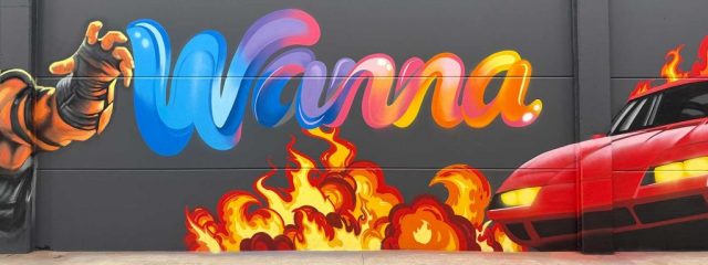 Graffiti con logotipo Wanna, coche deportivo rojo y llamas de estilo arcade para centro de ocio.