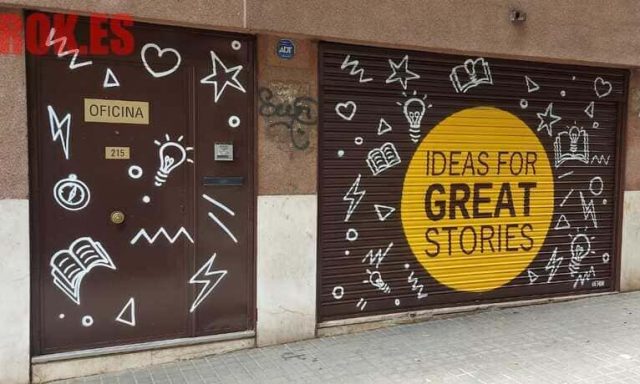 Graffiti decorativo en persiana y puerta de oficina con bombillas, libros y mensaje creativo.