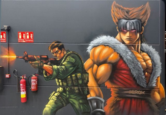 Graffiti de un guerrero de videojuego y un soldado armado pintados sobre una pared negra.