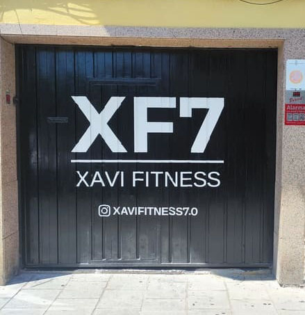 Rotulación artística del logotipo XF7 Xavi Fitness sobre una puerta de gimnasio.