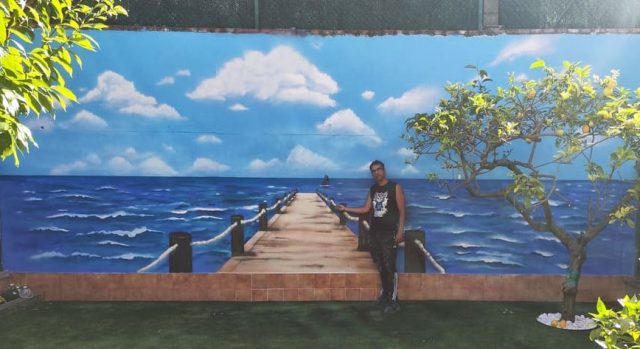 Mural decorativo con una pasarela de madera que conduce hacia el mar y el horizonte.