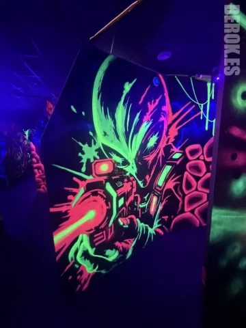 Mural Fluorescente de Guerrero Alienígena - Pintura UV Reactiva con Arma Mural fluorescente de guerrero alienígena con arma láser pintado con sprays UV, efecto glow en laser tag