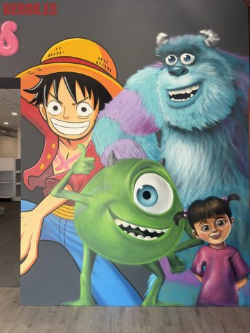 Mural con Monkey D. Luffy de One Piece, Sulley, Mike Wazowski y Boo de Monstruos, S.A. pintados sobre una pared con estilo cartoon.