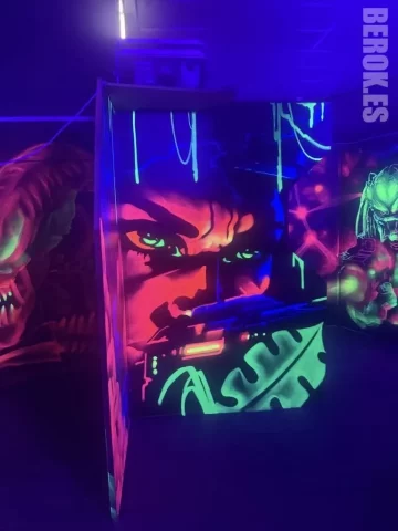 Graffiti personaje de acción fluorescente Laser Tag Graffiti fluorescente de personaje de acción con rifle láser y mural Predator pintado con pintura UV para Laser Tag.