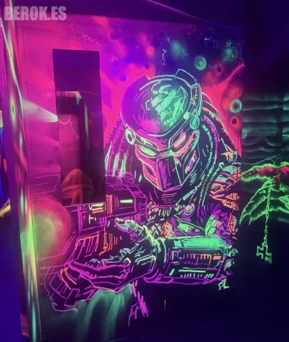 Graffiti Predator fluorescente para Laser Tag. Graffiti fluorescente de Predator con arma láser para Laser Tag pintado a mano con luz UV.