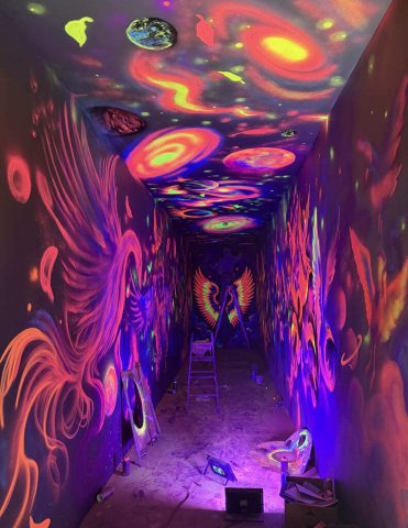 Mural fluorescente planetas galaxias nebulosas estrellas y alas Mural fluorescente con planetas galaxias nebulosas estrellas remolinos cosmicos y alas bajo luz ultravioleta