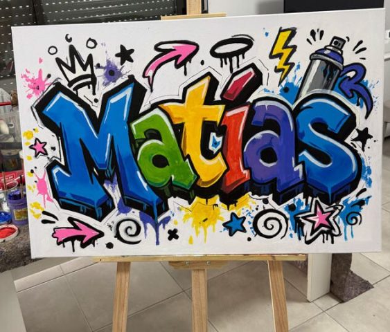 Cuadro sobre caballete con el nombre Matías en letras graffiti azules, amarillas y verdes y adornos de estrellas.