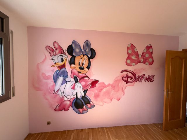 Minnie Mouse y Daisy pintadas junto al nombre Dafne y un lazo sobre la pared rosa de una habitación infantil.