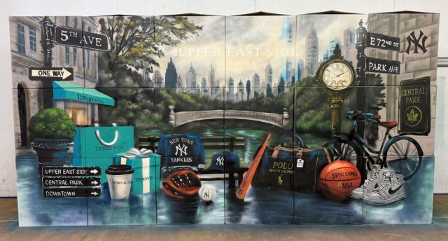 Vista frontal de un mural con Central Park, skyline de Nueva York, señales, bicicleta y objetos urbanos pintados.
