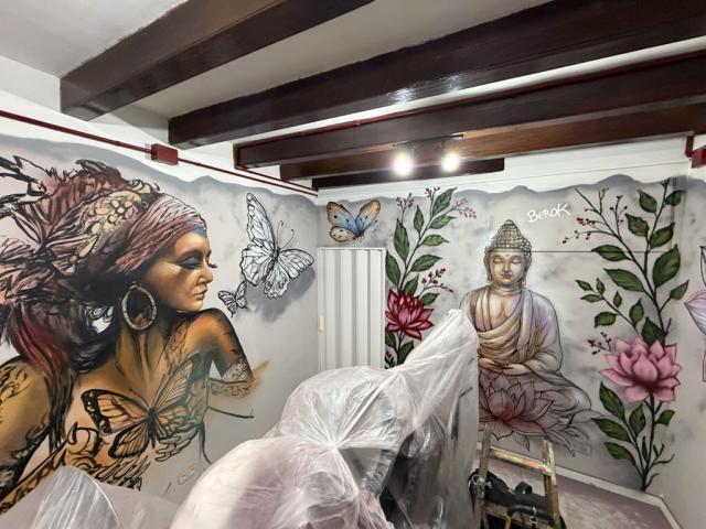 Conjunto de murales de mujer, Buda y flores Vista del conjunto de paredes pintadas con una mujer, mariposas, Buda y flores de loto durante la decoración del interior.