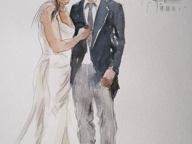 Detalle del retrato de novios sobre papel de acuarela Vista cercana de una acuarela de pareja con vestido blanco y traje oscuro junto a un pequeño dibujo de un edificio.
